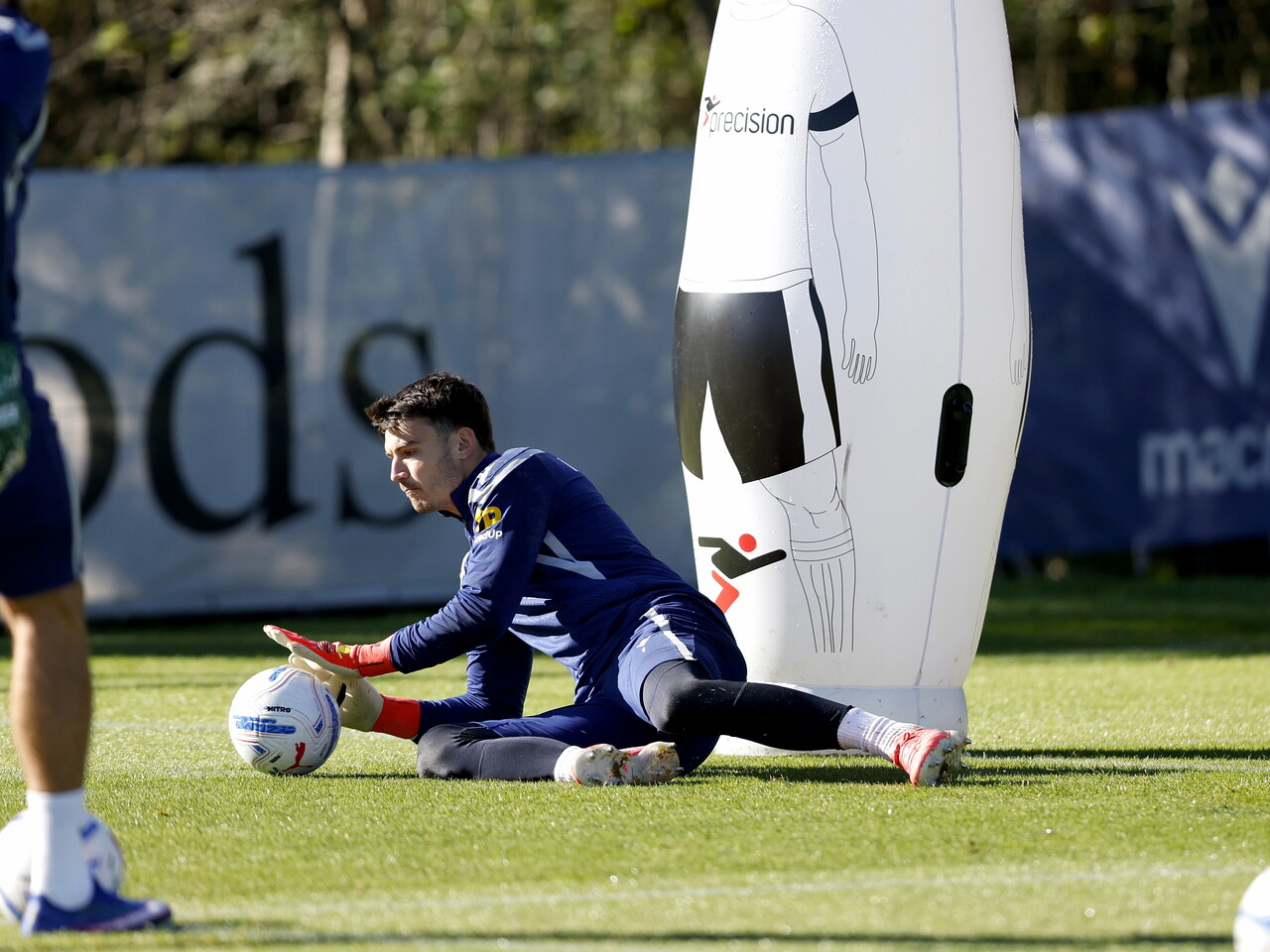 Max O'Leary diving down low to catch a ball during a training session