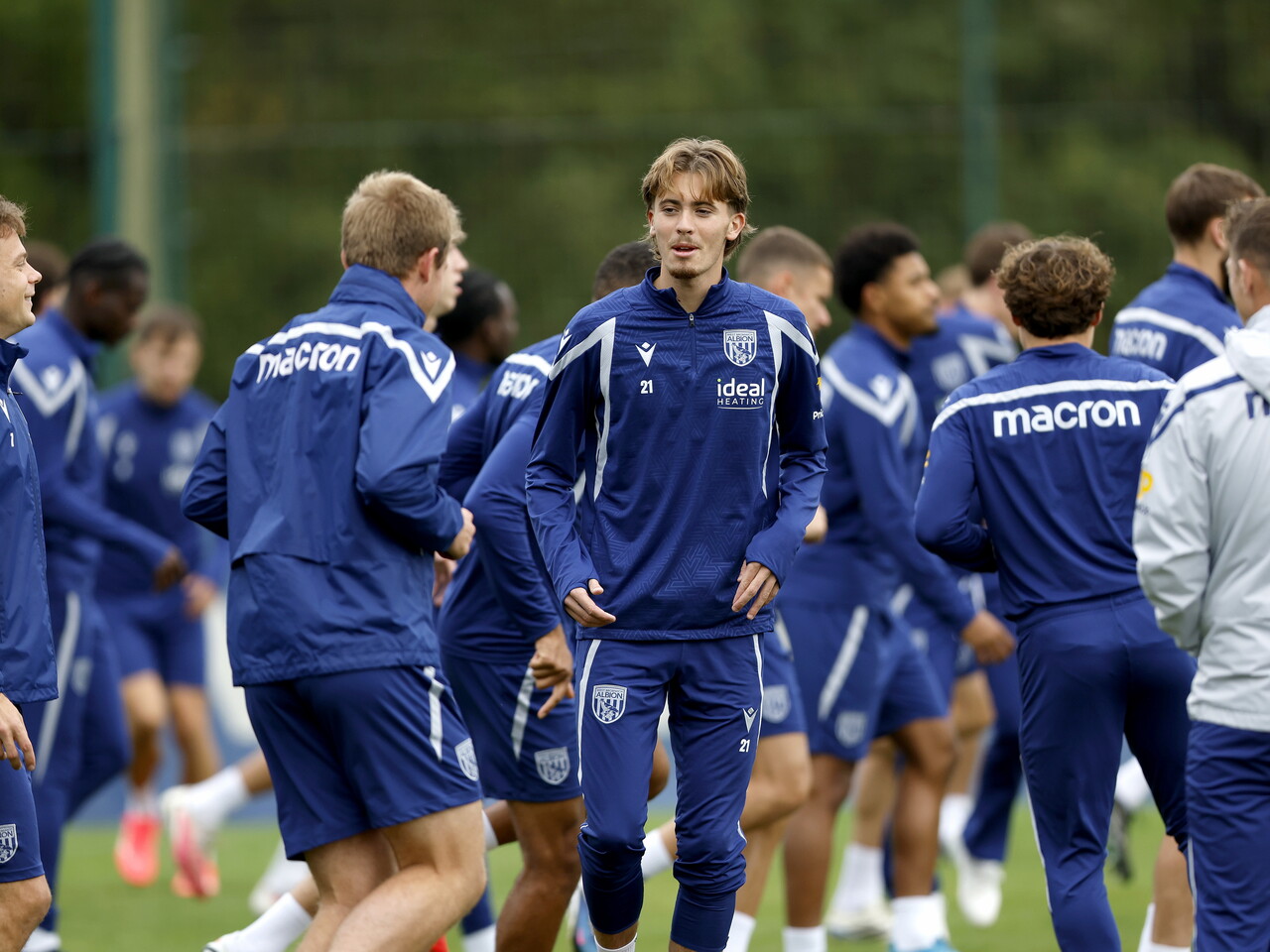 Isaac Price chatting to team-mates during the warm-up of a training session
