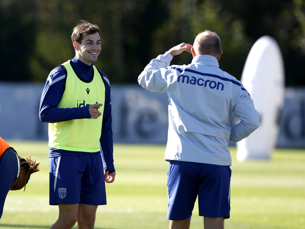 Jayson Molumby laughing with a coach during a training session