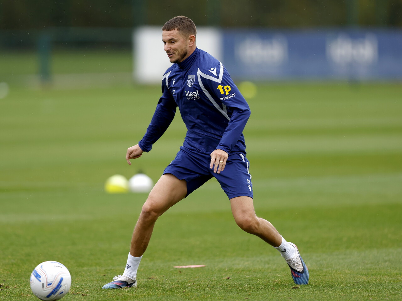 Conor Townsend smiling during a training session while on the ball