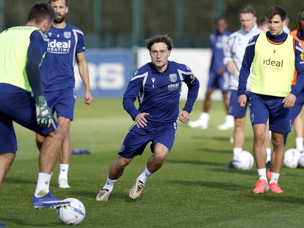 Callum Styles running towards the ball and closing down a player in possession during a training session