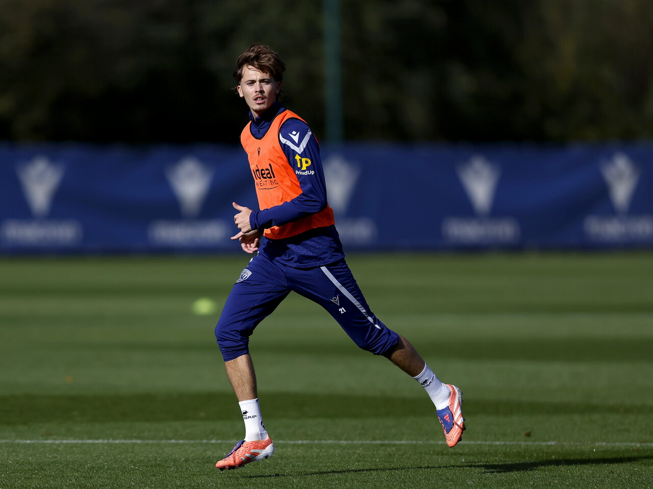 Isaac Price running and looking for the ball during a training session