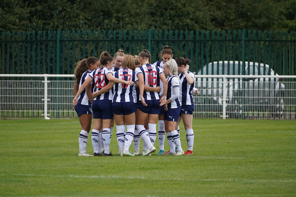 An image of the Albion Women team in a huddle before a match