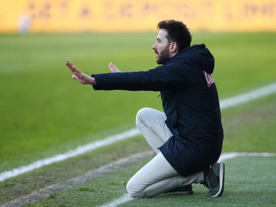 An image of new Albion boss Carlos Corberan crouching and giving instructions to his team