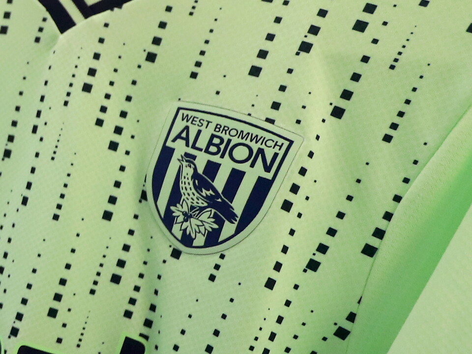 An Albion badge on the lime green away kit 