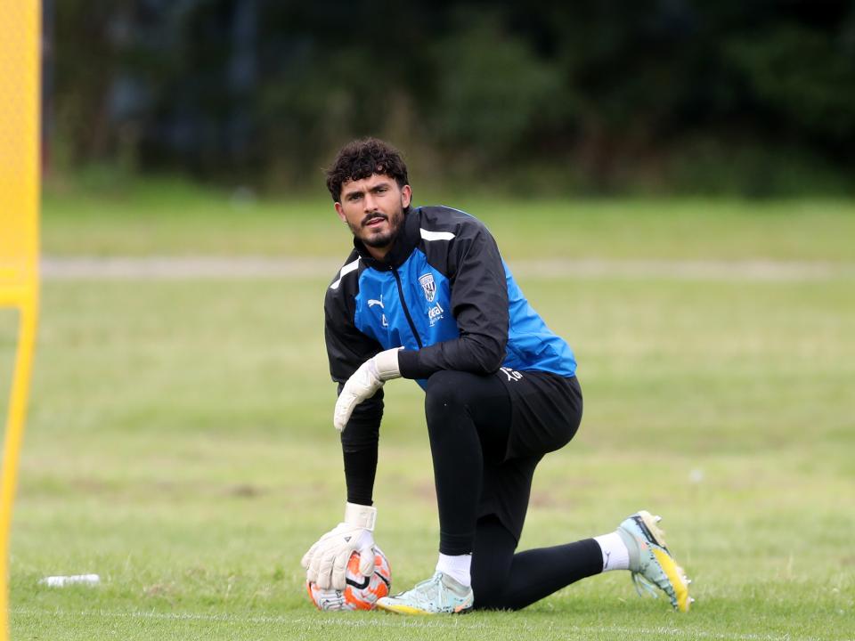 Brad Foster kneeling down with the ball under his hand in training