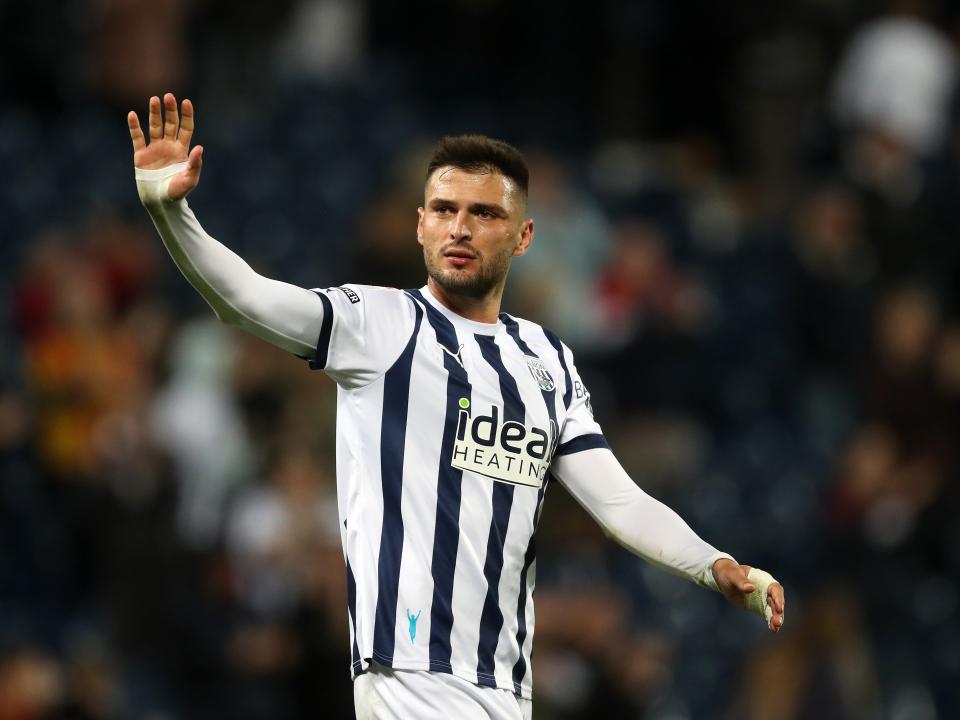 A photo of Okay Yokuslu, in the 2023/24 home colours, waving at Albion supporters at The Hawthorns following a 2-1 win over Sheffield Wednesday