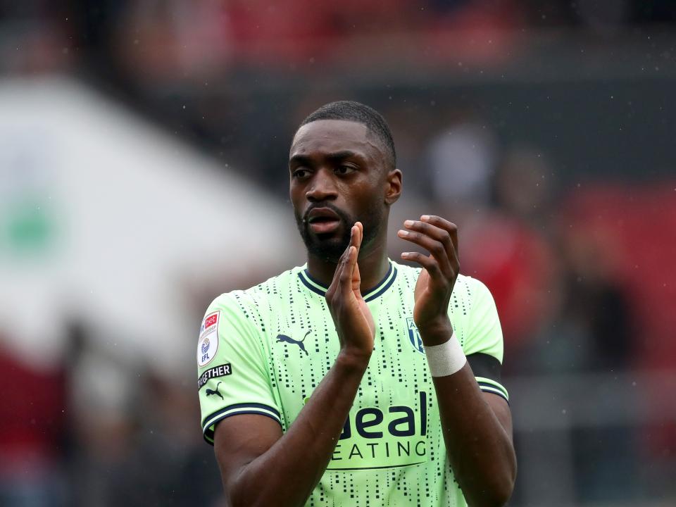Semi Ajayi applauding Albion fans while wearing the lime green kit