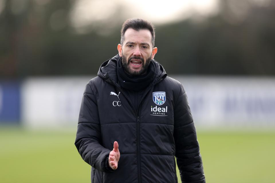 Carlos Corberán in a coat during a training session