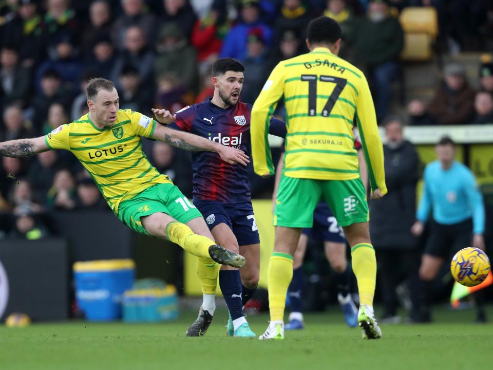 An image of Alex Mowatt trying to tackle Norwich's Ashley Barnes