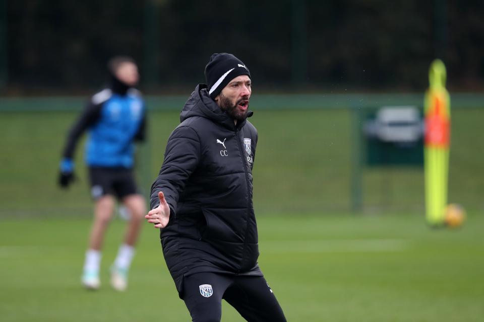 Carlos Corberán wearing a hat and a coat in the middle of the training session