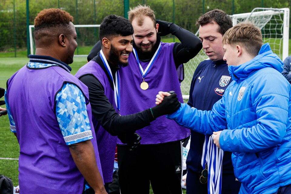 Player shaking hands and receiving medals.
