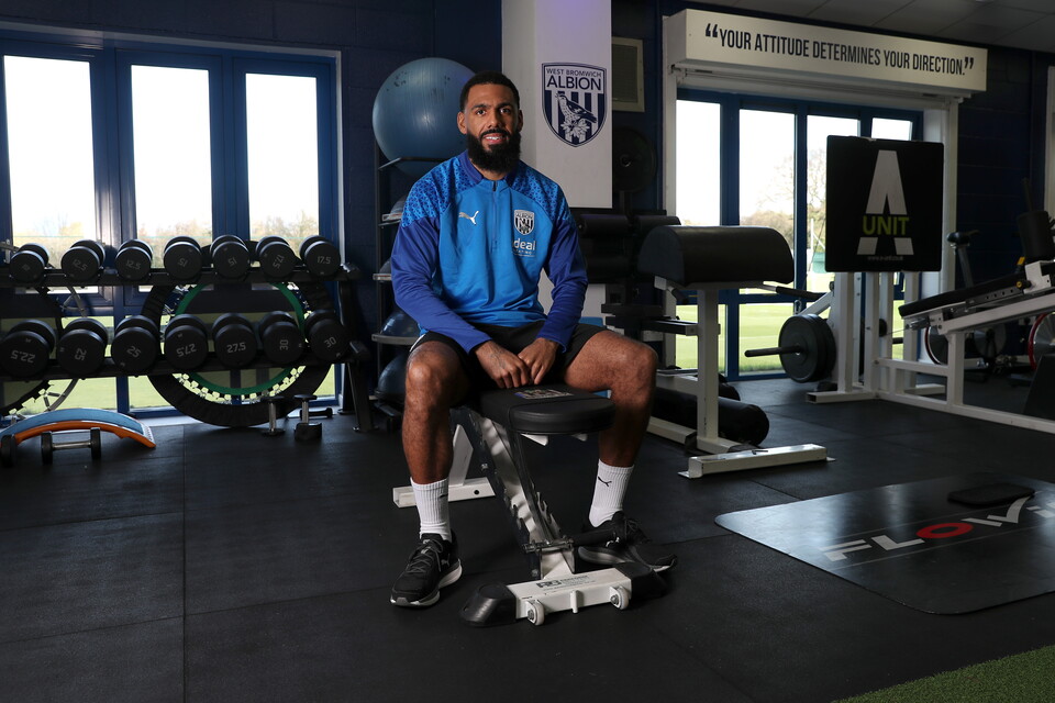Yann M'Vila sat looking at the camera smiling in the gym