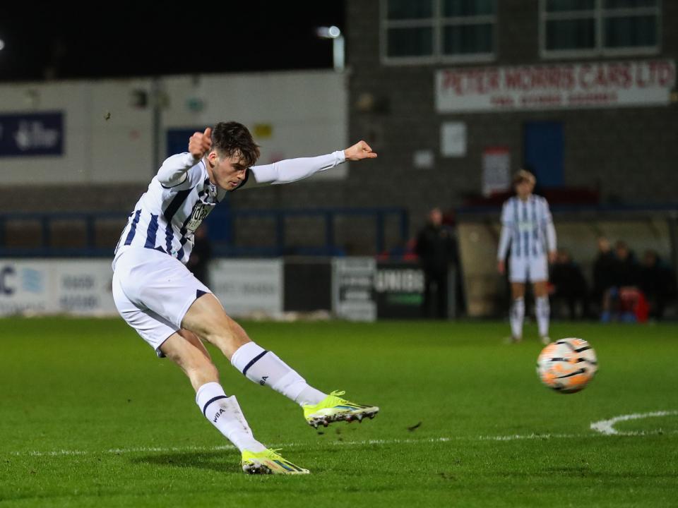 A photo of Albion U21s defender Alex Williams, in the 2023/24 home kit, striking a ball in a PL2 game v Wolves