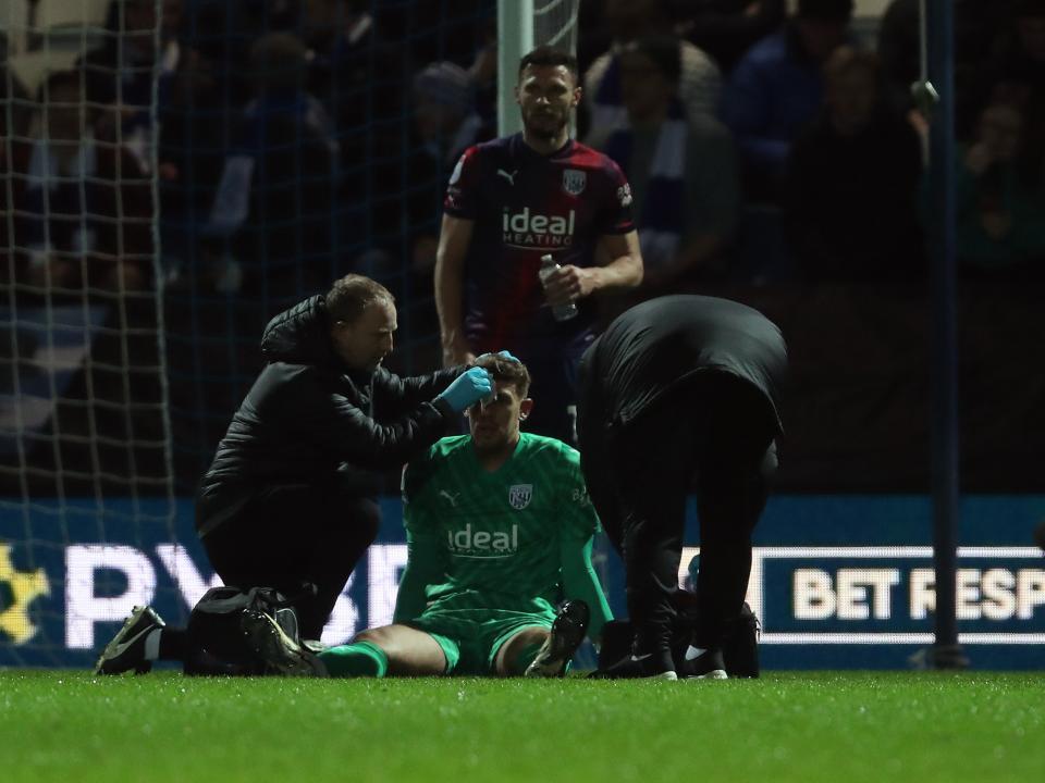 A photo of Alex Palmer receiving treatment during Albion's away game against QPR
