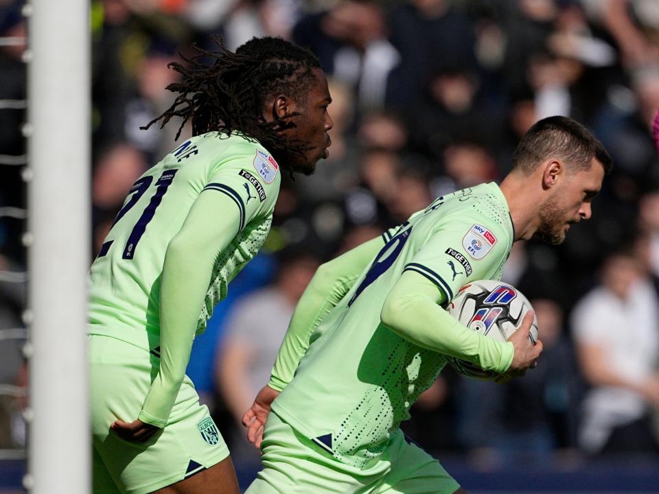 An image of John Swift and Brandon Thomas-Asante grabbing the ball from the net at Millwall