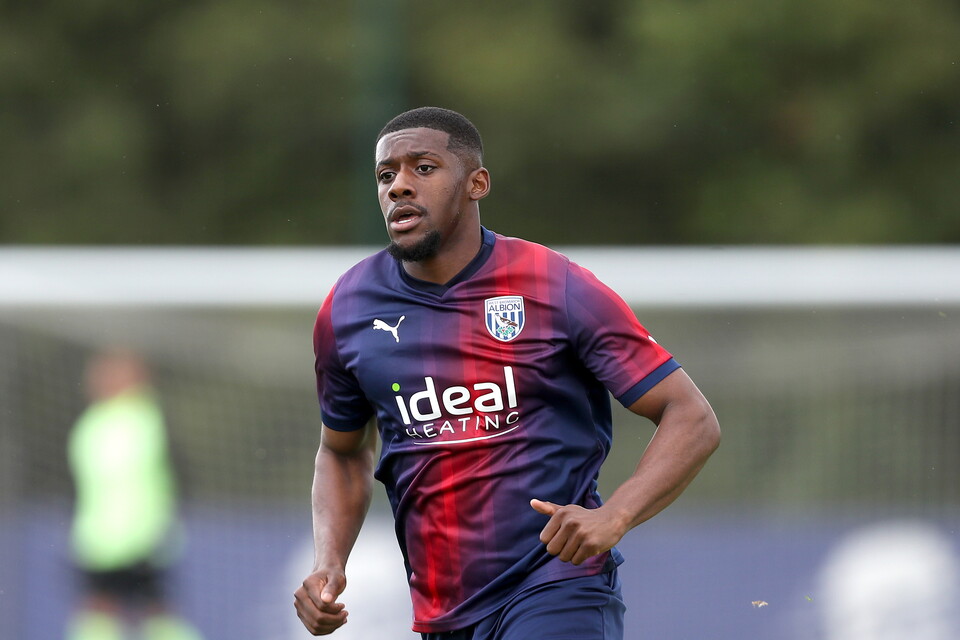 Jovan Malcolm in action for Albion while wearing the navy-blue-and-red away kit