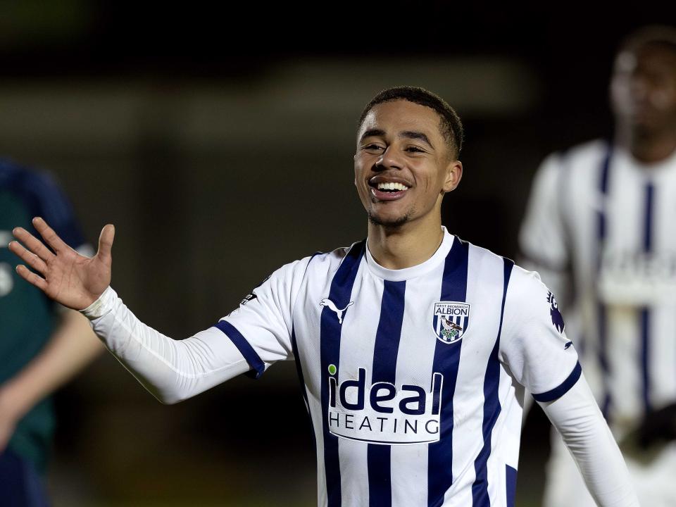 Deago Nelson smiling wearing the home kit during a PL2 fixture