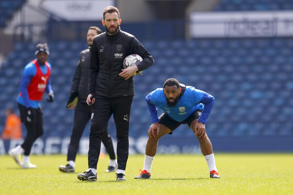 Carlos Corberán holding a ball in the middle of a training session at The Hawthorns