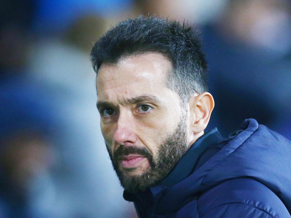 Carlos Corberán in a coat looking to his left