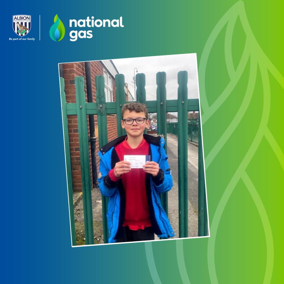 Tyler standing next to gate, holding a WBA ticket.