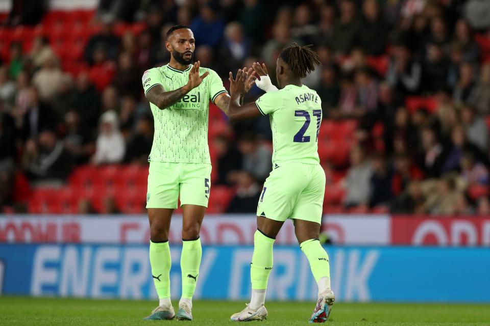 Brandon Thomas-Asante celebrates scoring for Albion at Stoke in the Carabao Cup in August 2023 wearing the lime green away kit
