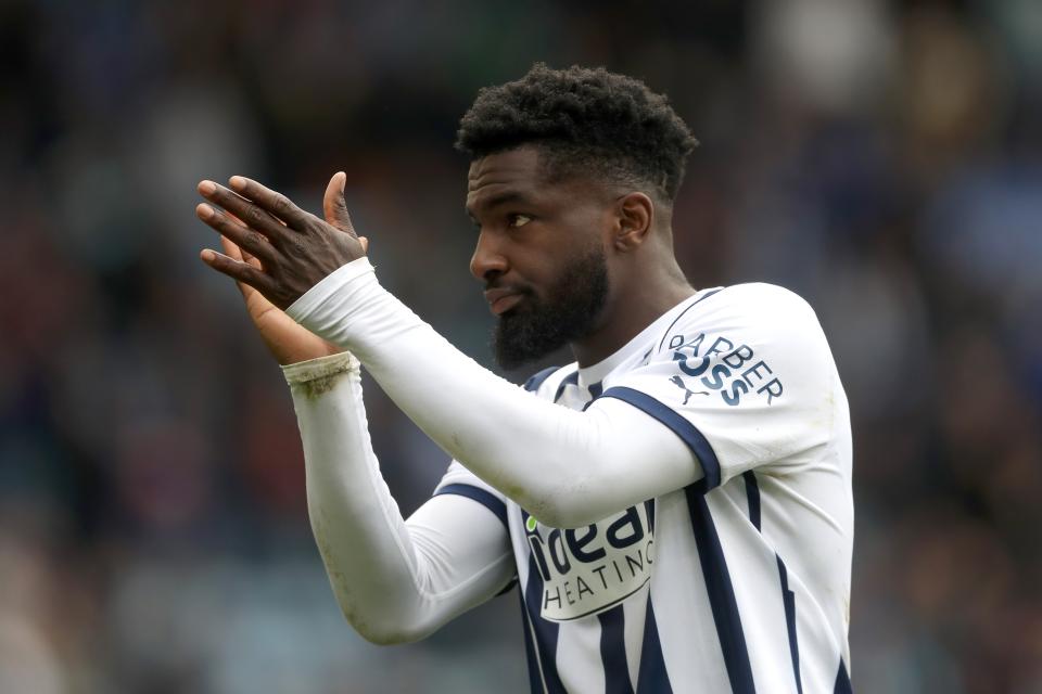 Cedric Kipre applauding Albion supporters while wearing the home kit 