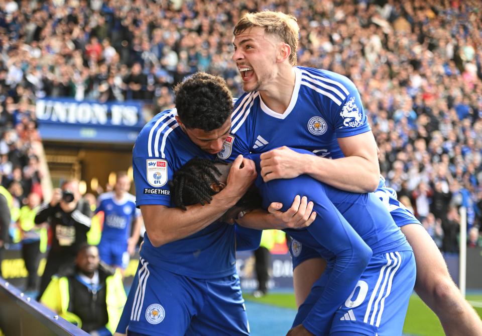 Stephy Mavididi celebrates with two team-mates after scoring a goal for Leicester in their home kit 