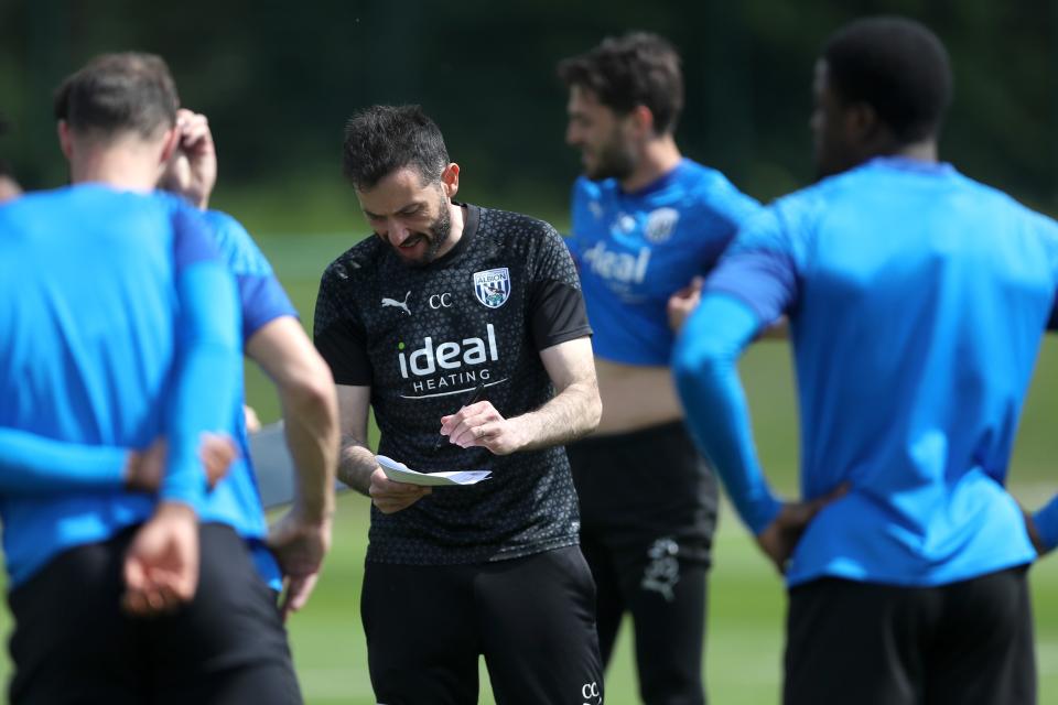 Carlos Corberán writing a note down during the middle of a training session