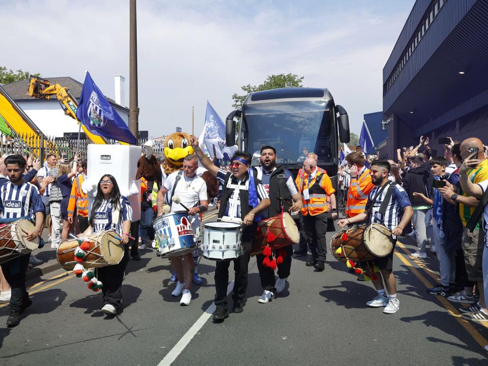 An image of Albion's team bus arriving, surrounded by Baggies supporters