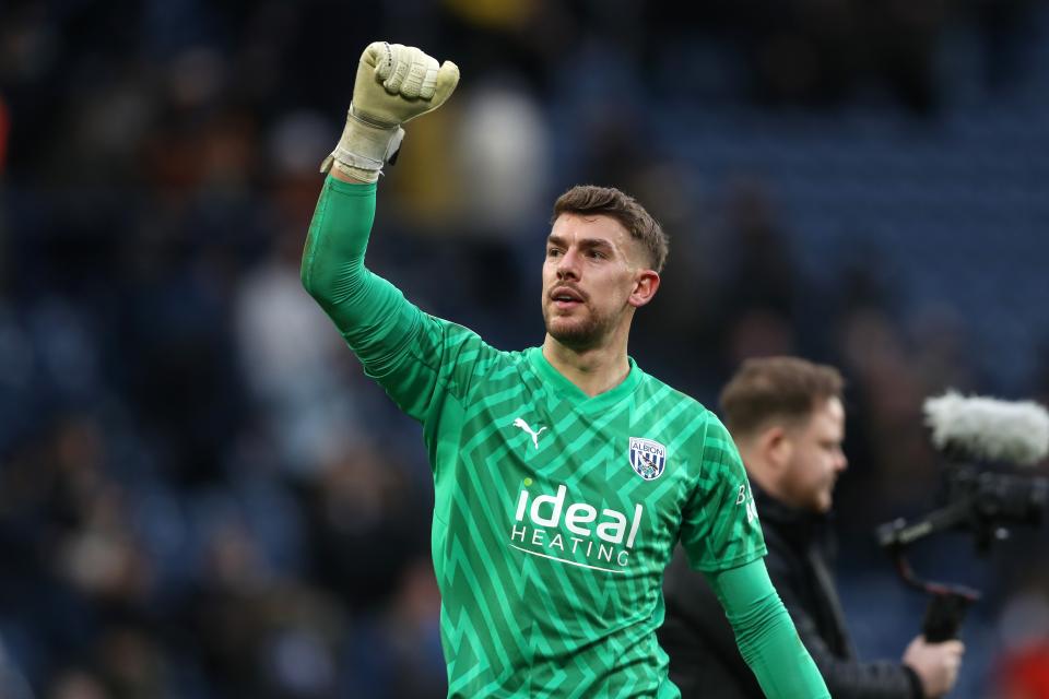 Alex Palmer punches the air after winning a game with Albion wearing the green goalkeeper kit 