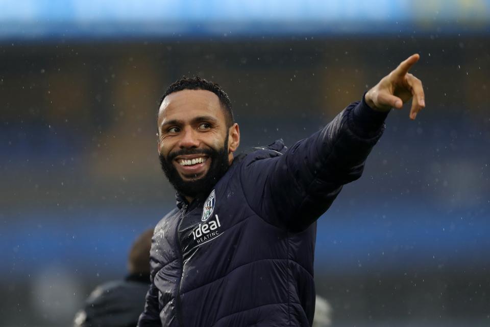 Kyle Bartley smiling and pointing while wearing an Albion coat