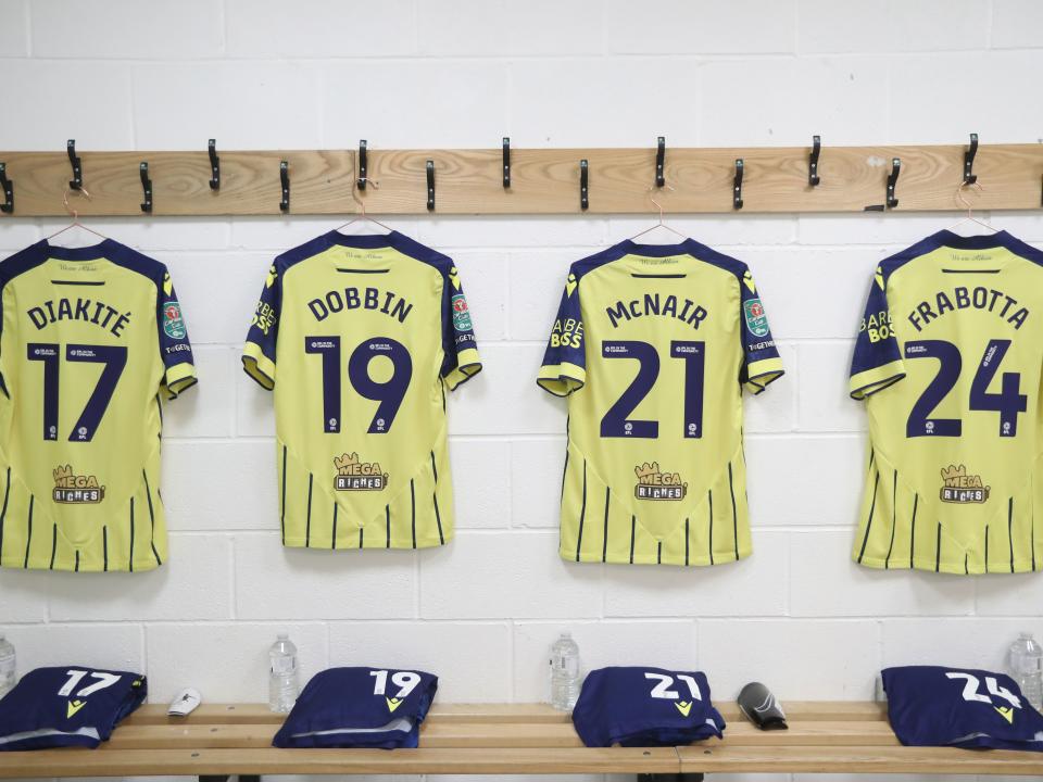 An image of Diakite, Dobbin, McNair and Frabotta's shirts hanging in the dressing room at Fleetwood