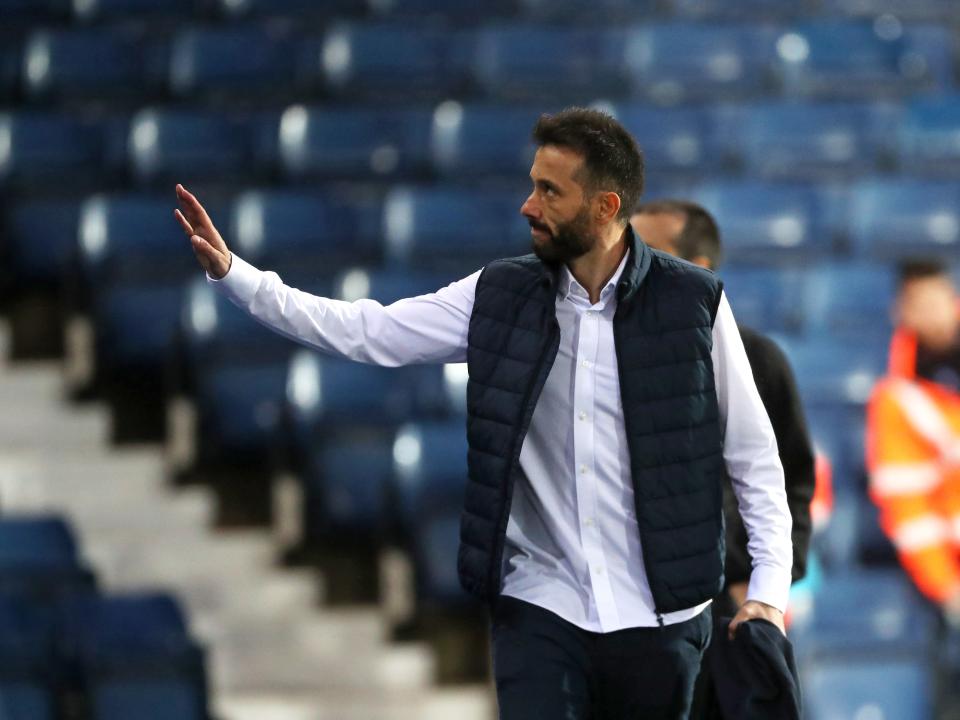 An image of Carlos Corberan waving to a supporter