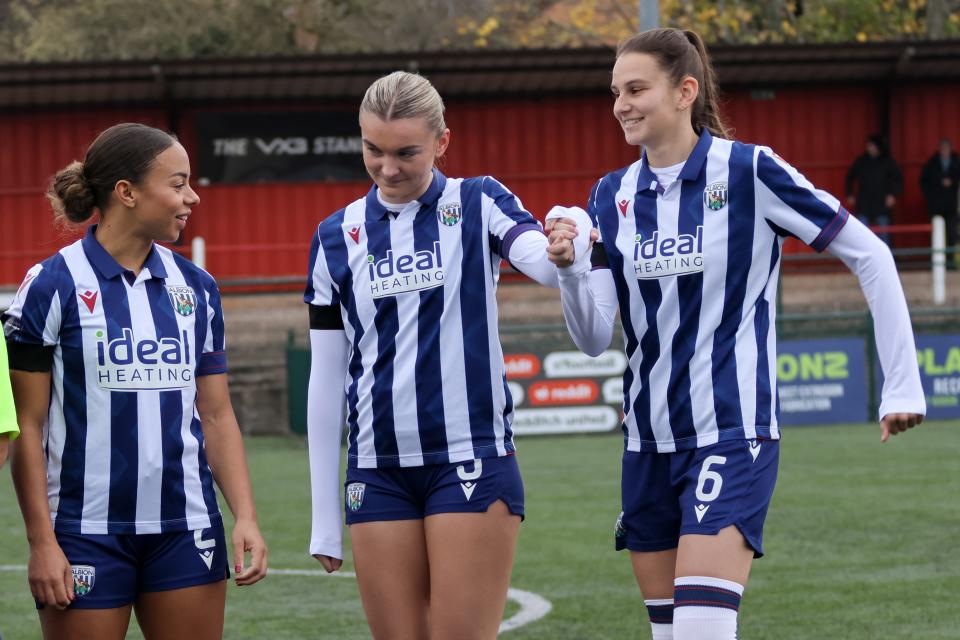 Ash Brown, Taylor Reynolds and Izzy Green laughing before a game in the home kit 