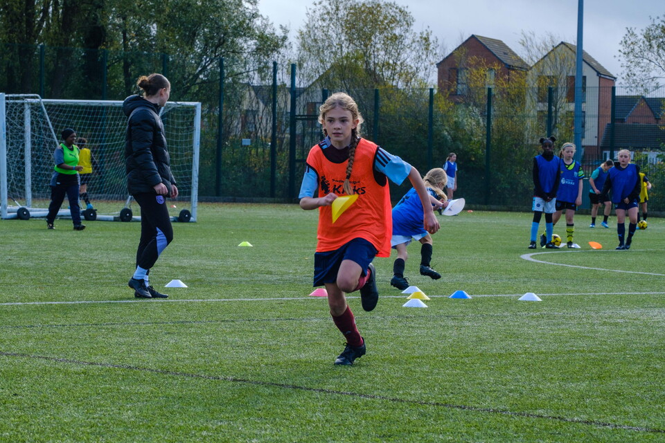 Girl running with a cone in hand.