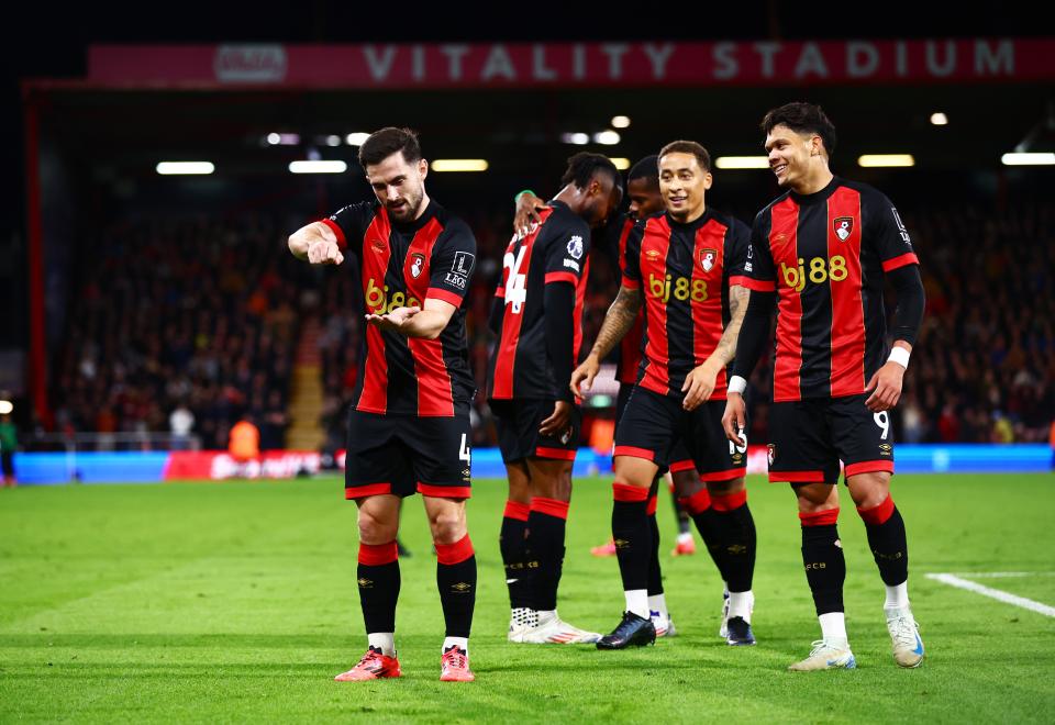 Several AFC Bournemouth players celebrate a goal of theirs in the home kit 