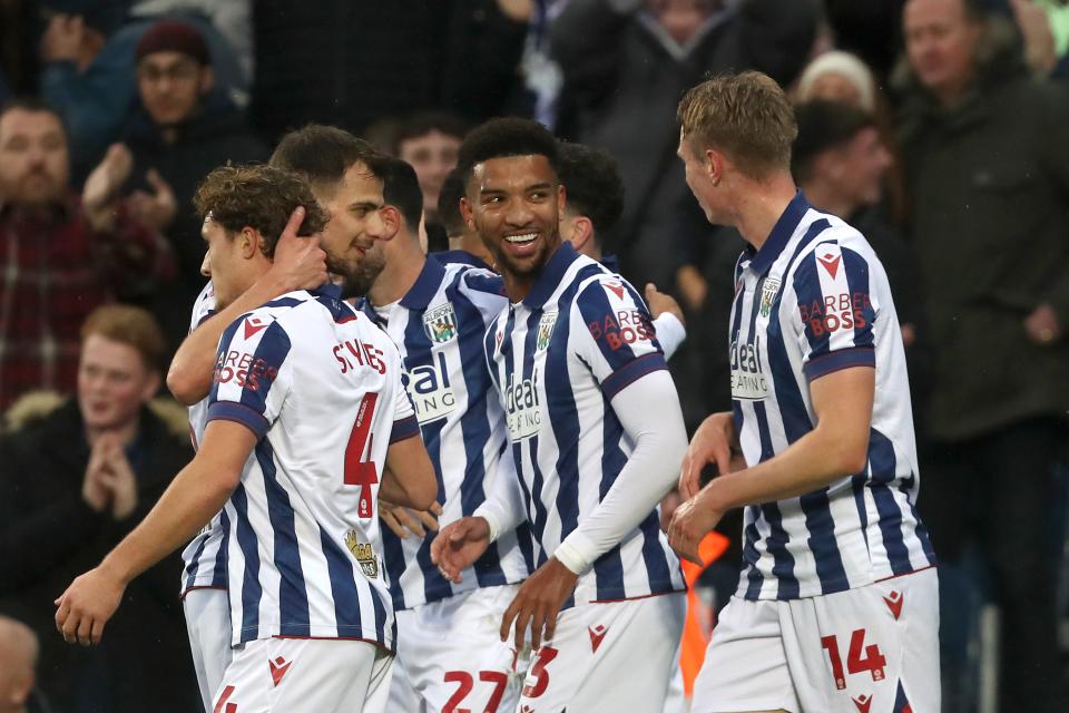 Several Albion players in the home kit celebrate a goal scored at The Hawthorns 