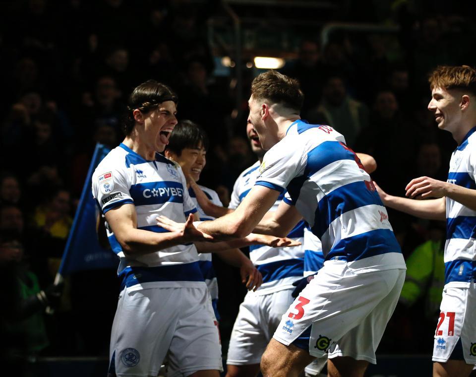 Several QPR players in their home kit celebrating a goal 