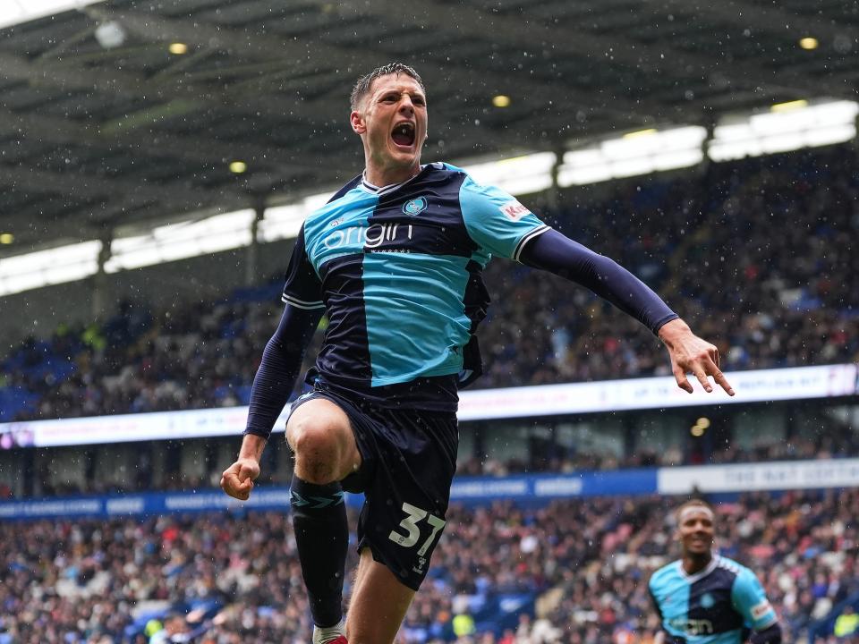 A photo of Albion defender Caleb Taylor celebrating a goal for loan club Wycombe, in their sky and navy blue home kit