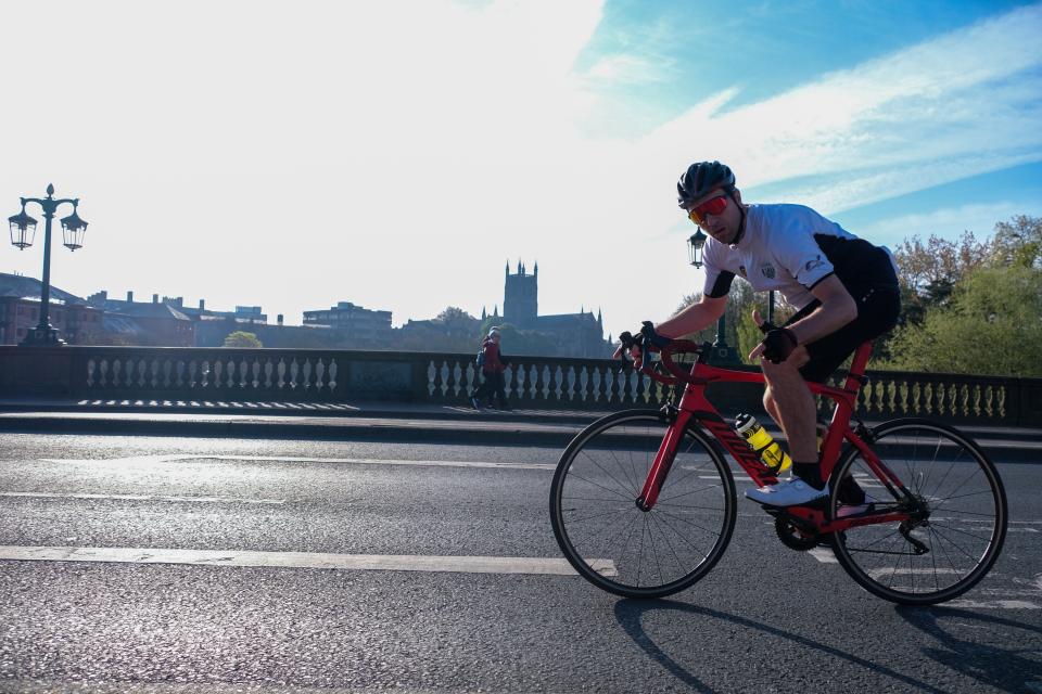 A cyclist rides over Worcester Bridge.