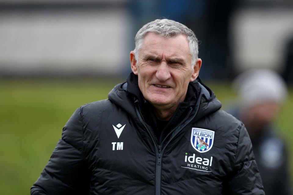 Tony Mowbray smiling on the training pitch wearing a black WBA coat 