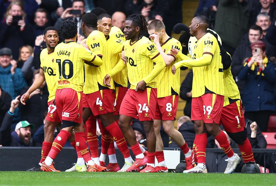 Several Watford players celebrating a goal scored in their home kit 