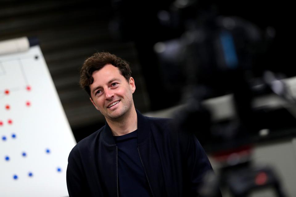 Ryan Mason smiling while being interviewed in front of a tactics board