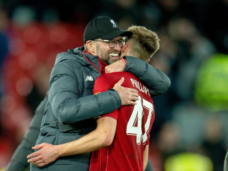 A photo of Nat Phillips and former Liverpool manager Jurgen Klopp embracing at Anfield