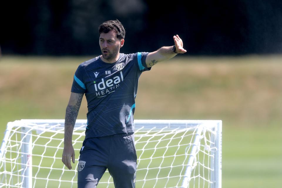 Ryan Mason with his left arm stretched out delivering instructions to his players on the training pitch 