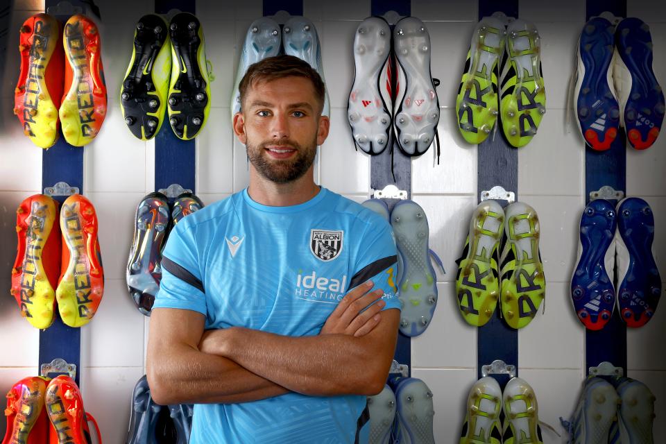 Charlie Taylor smiling at the camera while stood in the boot room