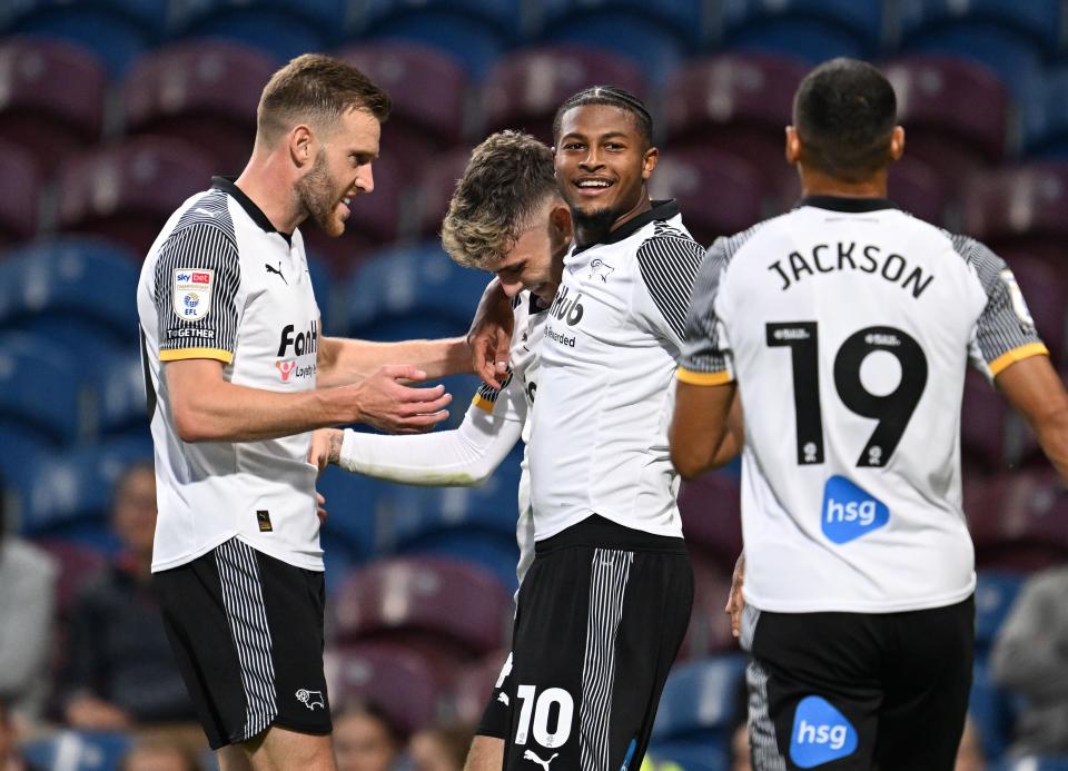 Four Derby players celebrate a goal scored in their home kit 