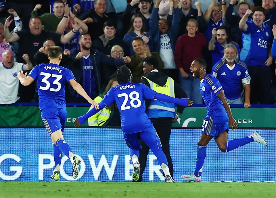Three Leicester City players celebrate a goal scored in their home kit 