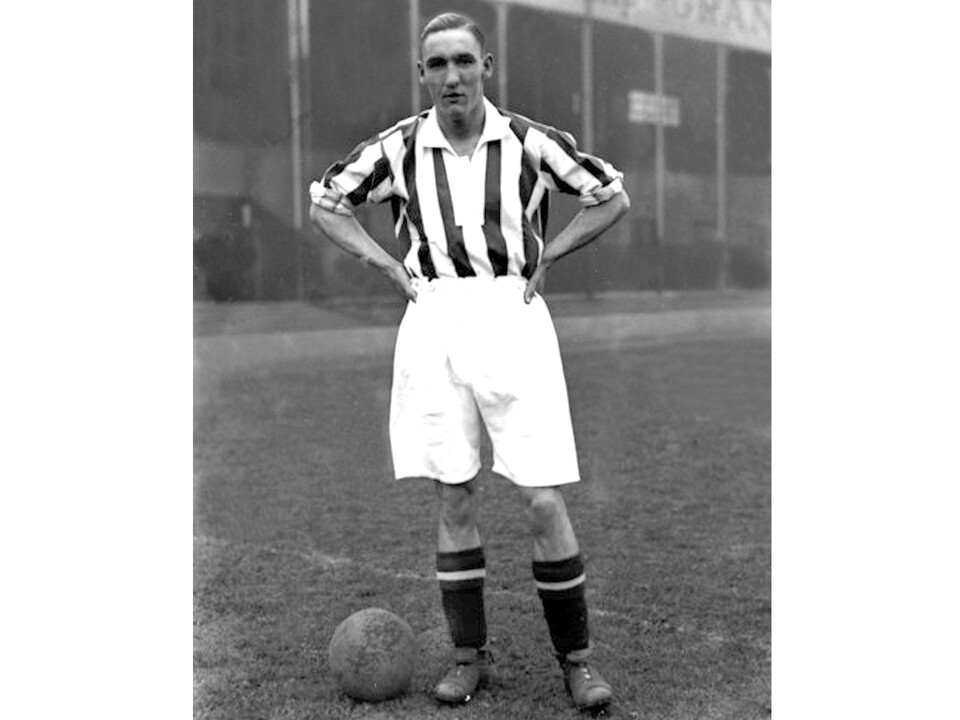 Harold White looking at the camera with his hands on his hips and a ball on the floor while wearing WBA kit 